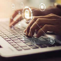 Business, technology, internet and networking concept. Young businesswoman working on his laptop in the office, select the icon security on the virtual display.